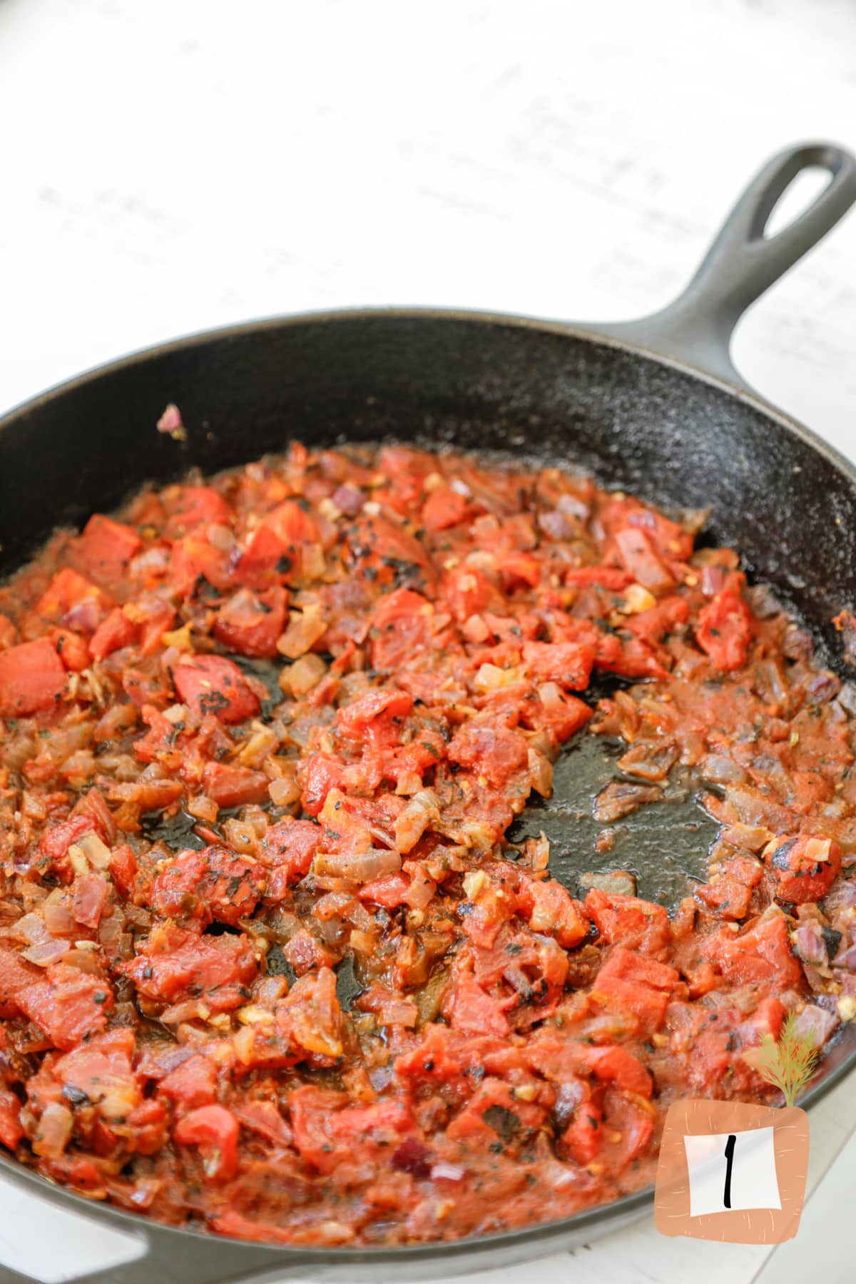 An iron skillet with tomato sauce.