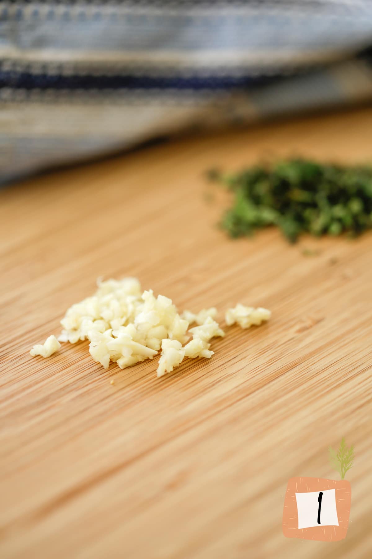 Minced garlic and cilantro on a cutting board.