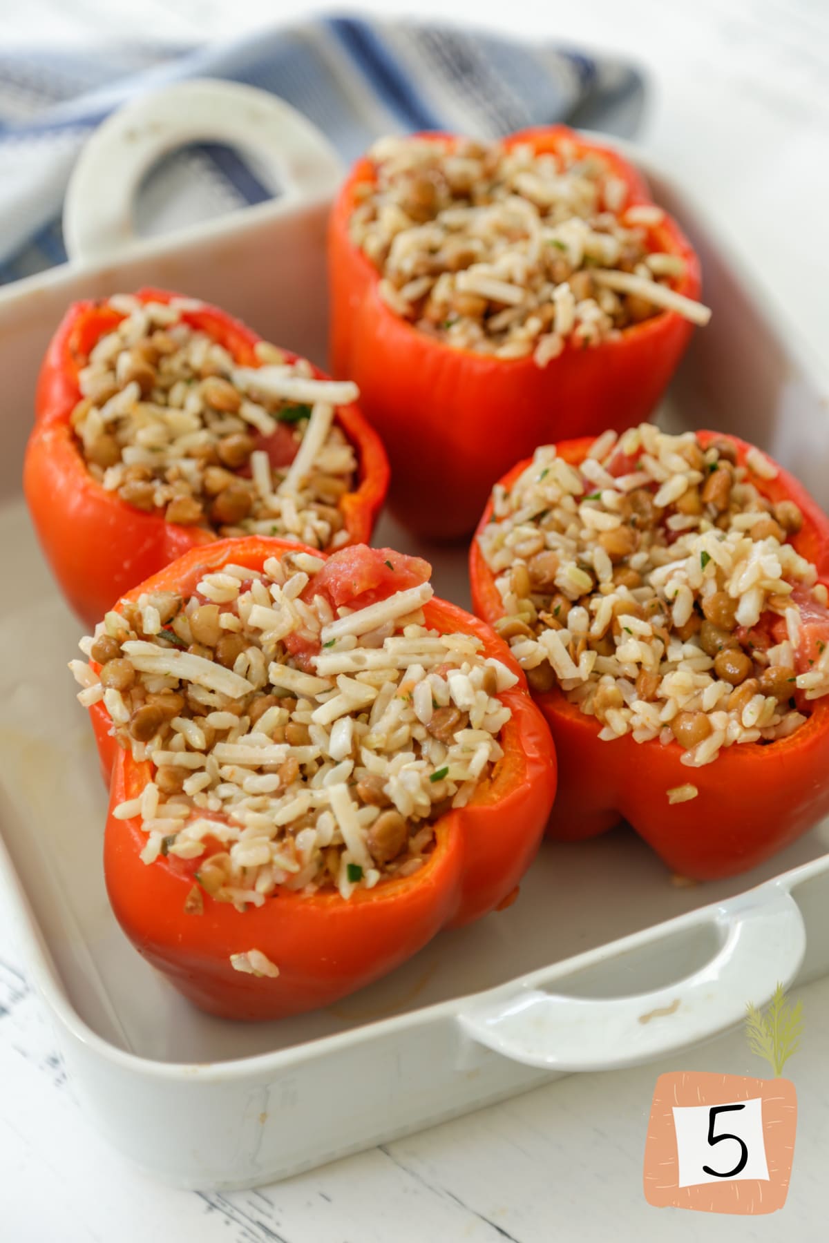 Unbaked stuffed peppers in a baking dish.