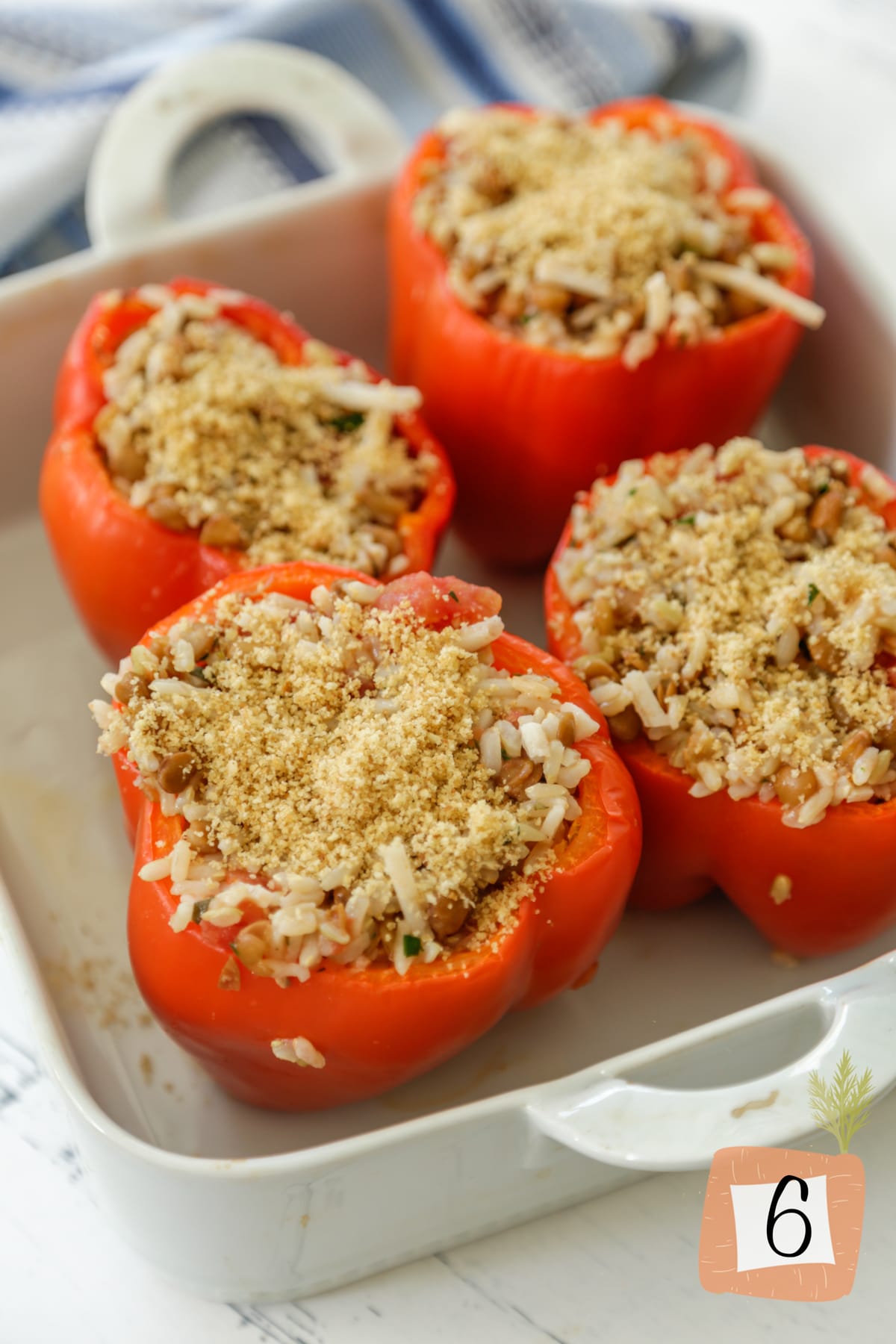 Stuffed peppers in a white baking dish before baking.