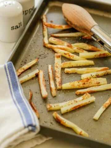 A baking sheet with french fries.