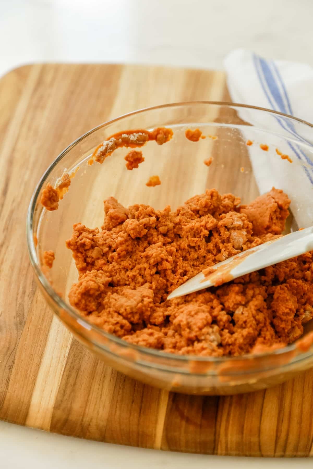 Vital wheat gluten in a glass bowl being stirred into seitan.